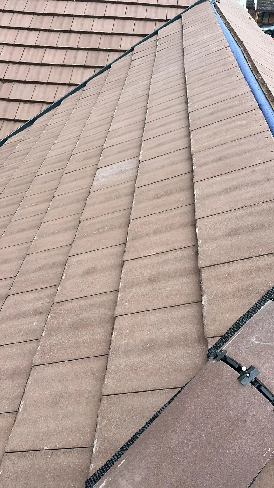 Close view of new brown plain tiles on a pitched roof