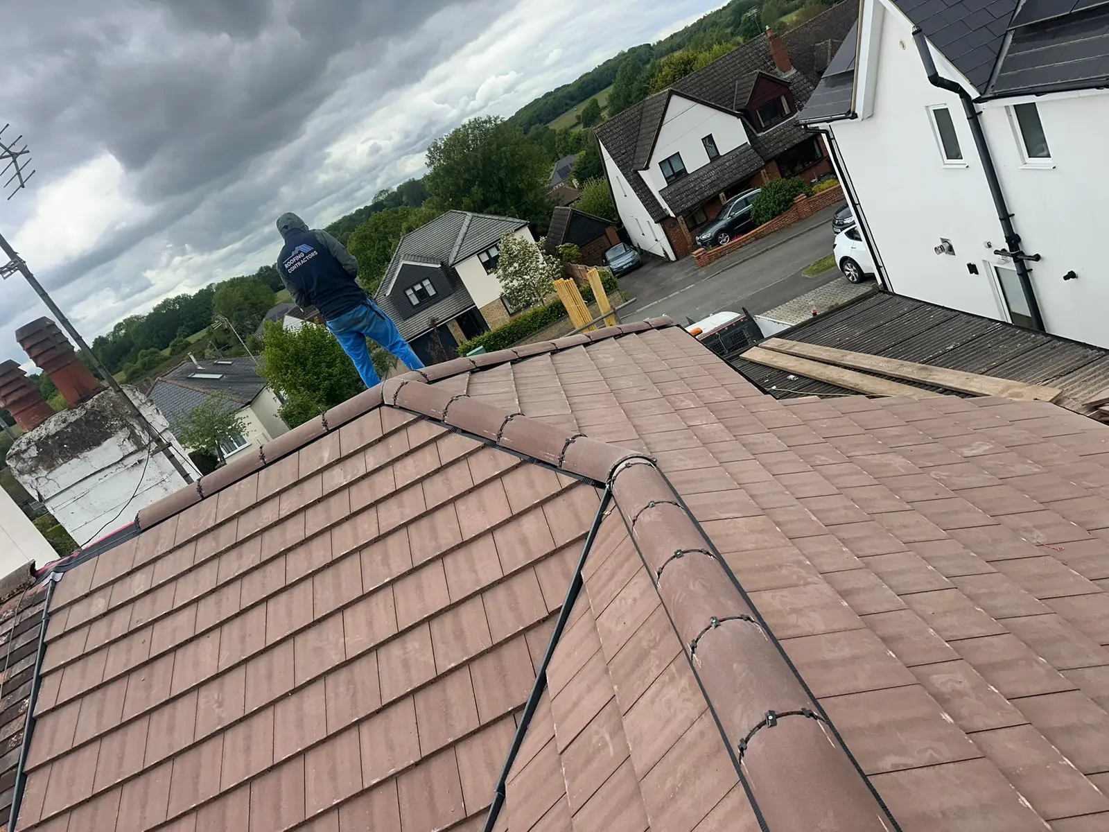 Roofer on a newly tiled hip roof