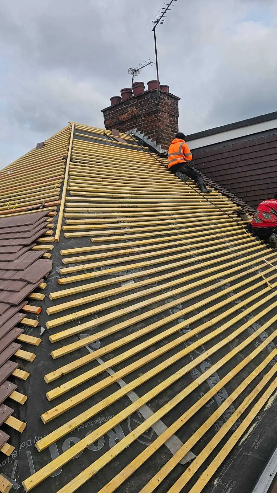 Roofer working across new battens