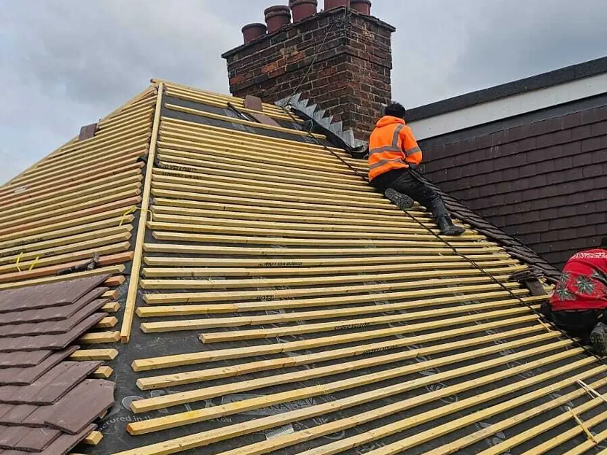 Roofer battening a roof ready for new tiles