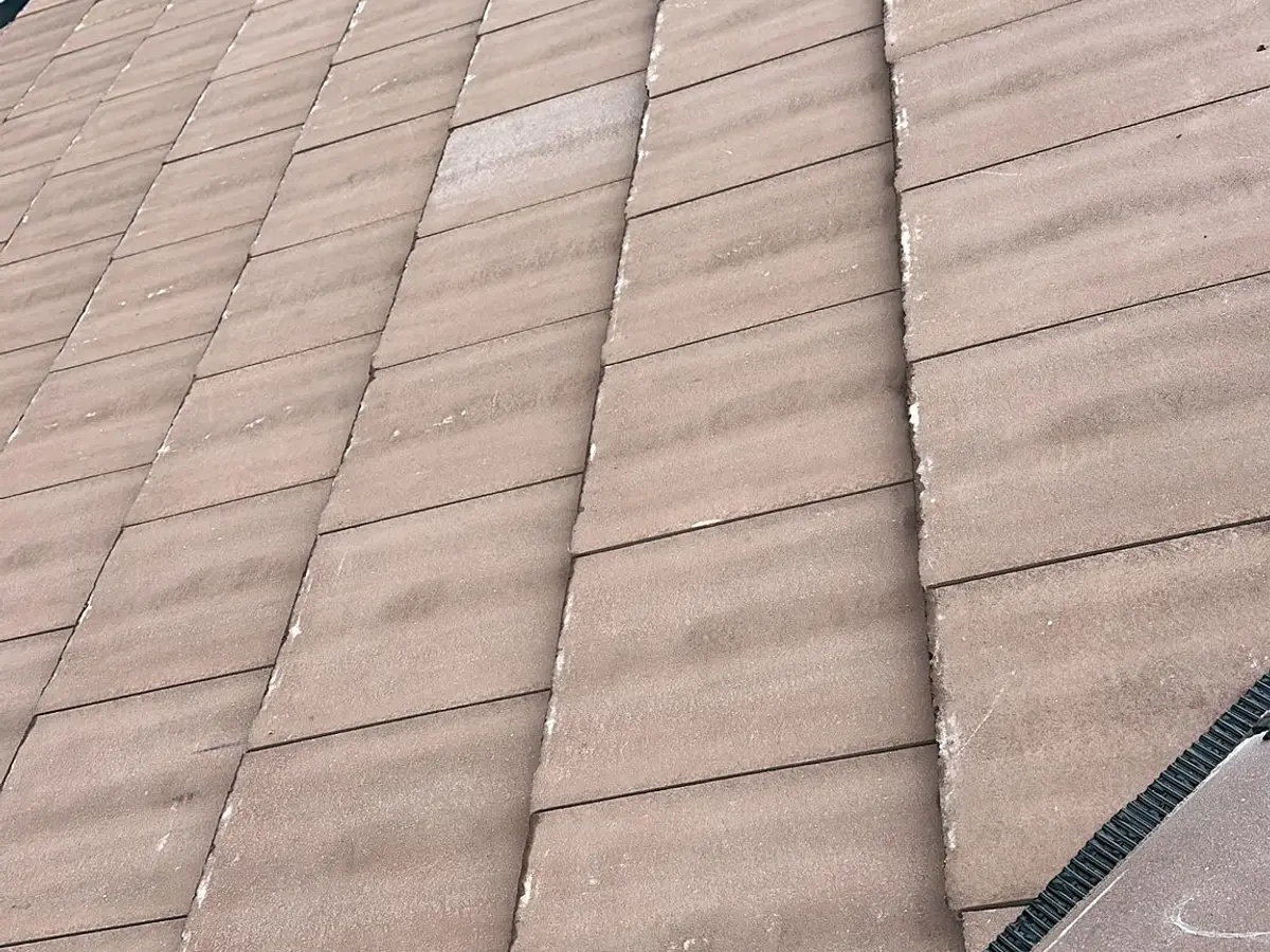 Close view of new brown concrete plain tiles on a finished roof