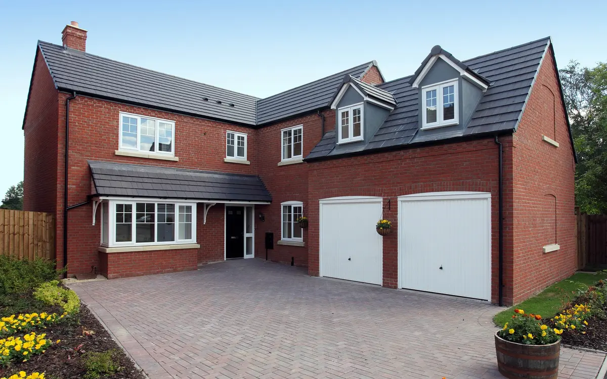 Detached brick house with a clean block paved driveway