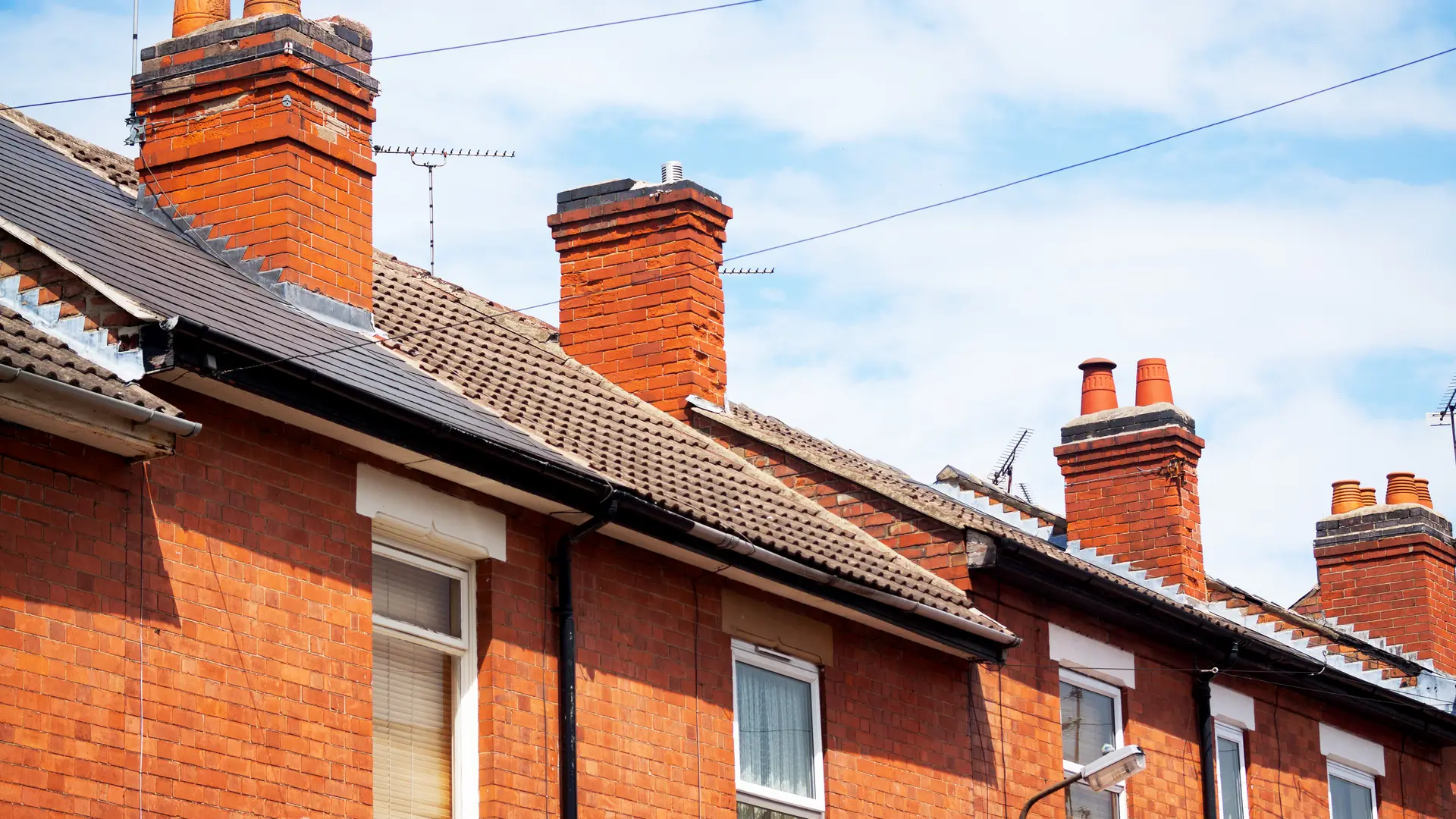 Red brick terraced houses with tiled roofs and chimney stacks