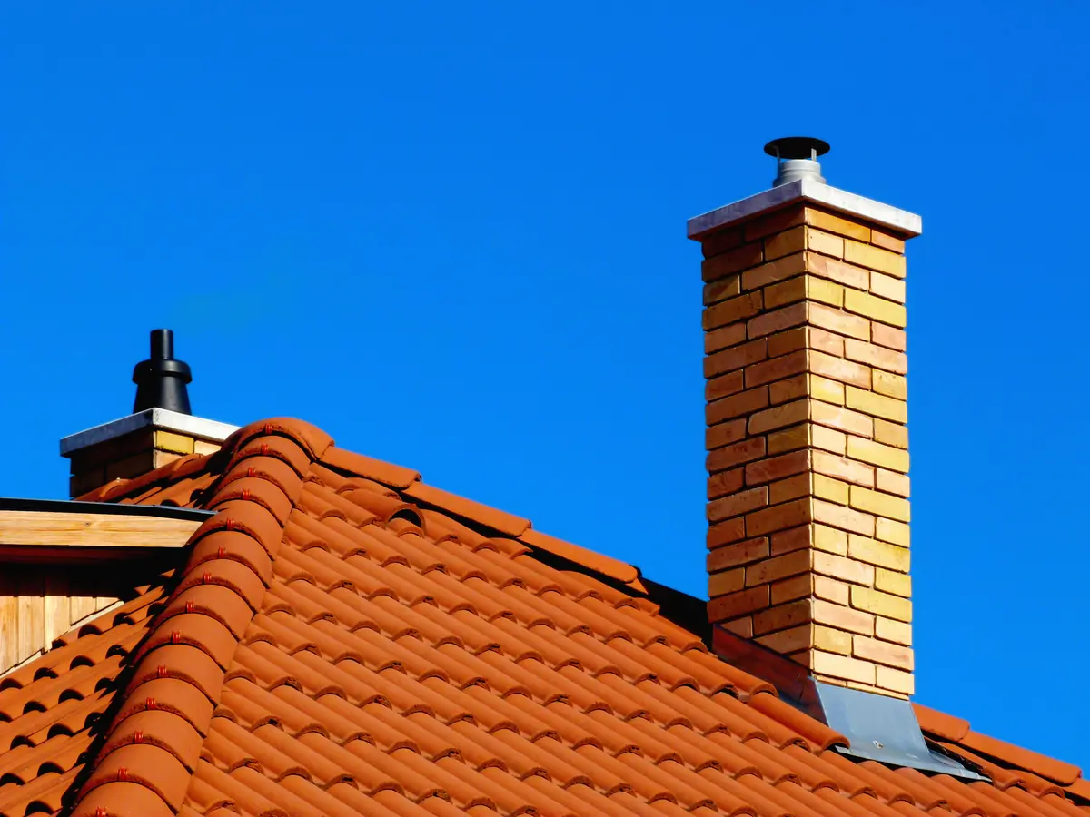 Brick chimney stack with lead flashing on a clay tiled roof