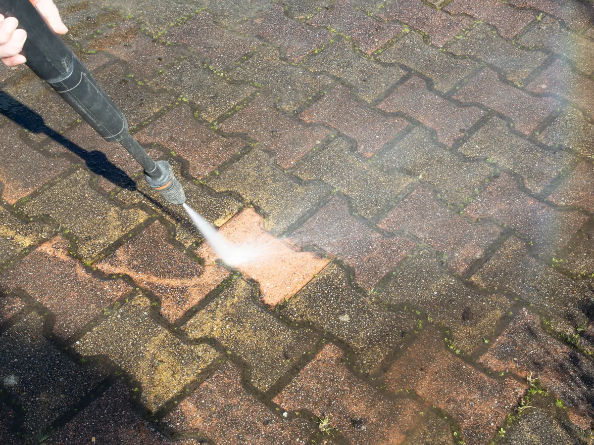Jet washing dirt and moss from block paving