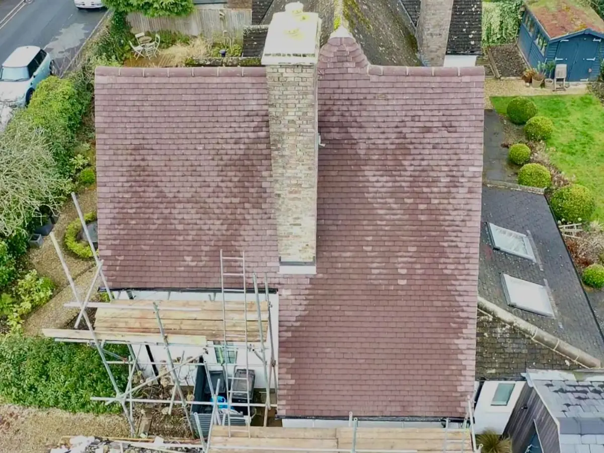Aerial view of a tiled roof and chimney with scaffolding up for repairs