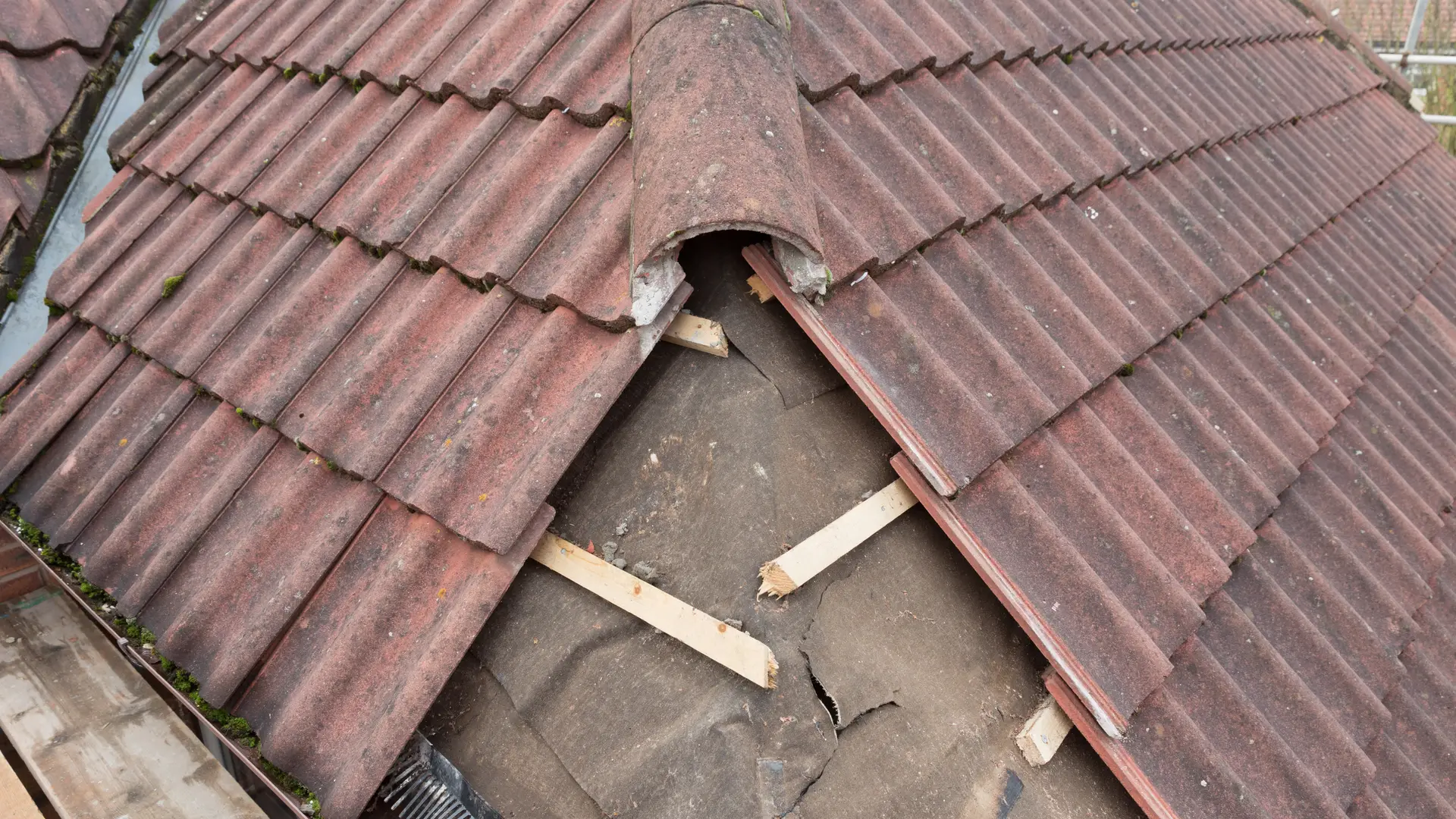 Interlocking concrete roof tiles lifted back to repair the felt and battens