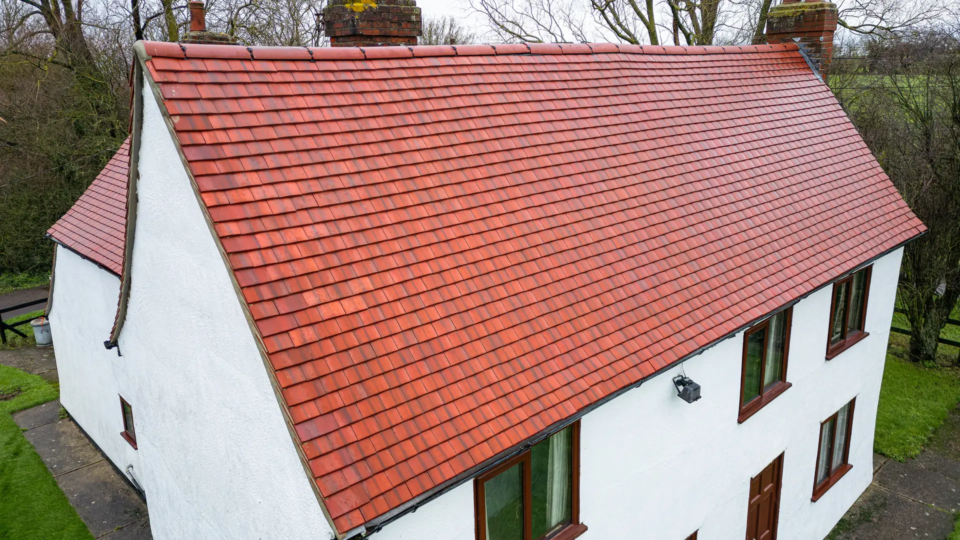 White cottage with a red clay plain tiled roof